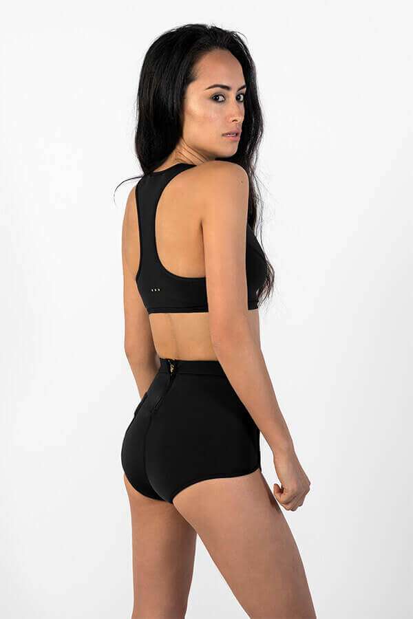 Scoop zip front sports crop bikini top made with Yulex + High waisted sustainable surf shorts - side view in studio
